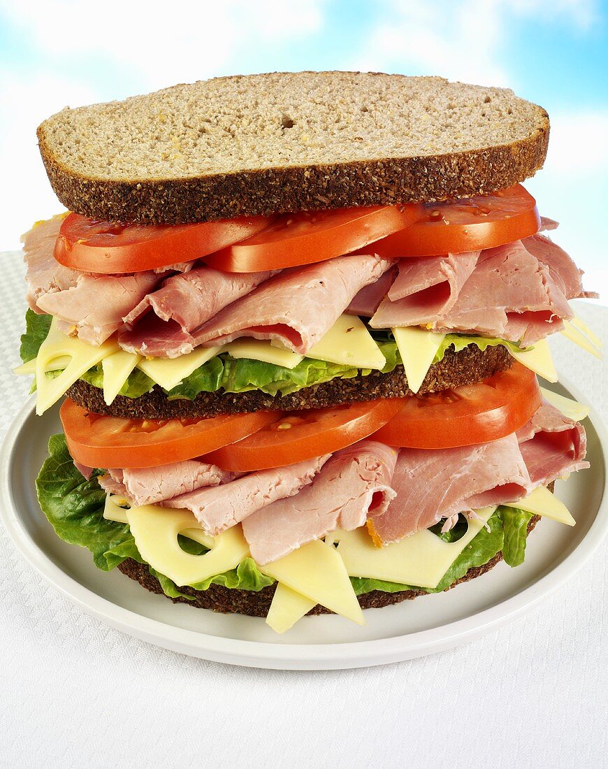 Double-decker ham, cheese, lettuce and tomato sandwich