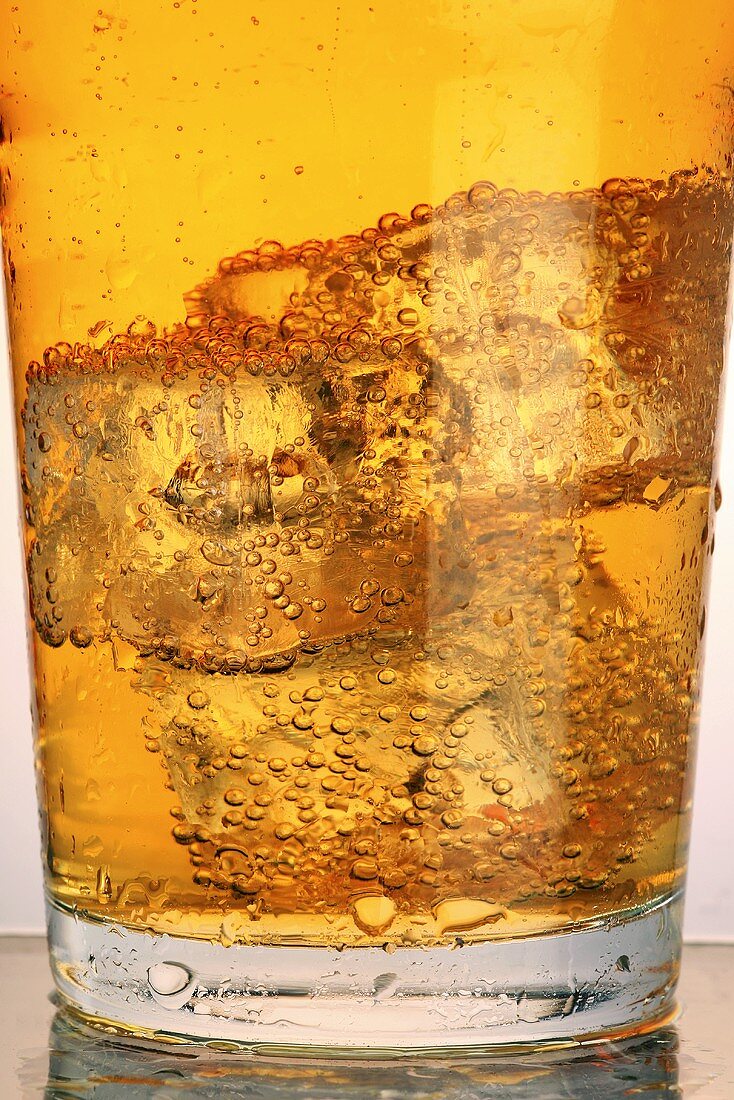 A glass of cider with ice cubes (close-up)