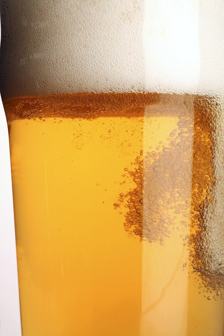 A glass of lager with a lot of head (close-up)