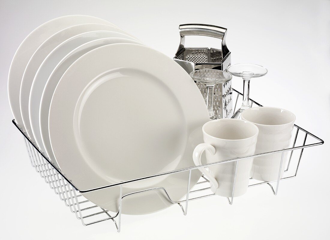 Plates, cups, glasses and grater on dish rack
