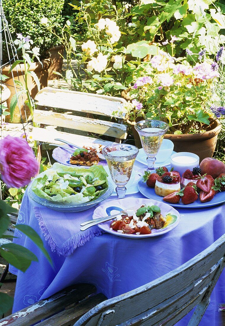 White wine, salad etc. on laid table out of doors