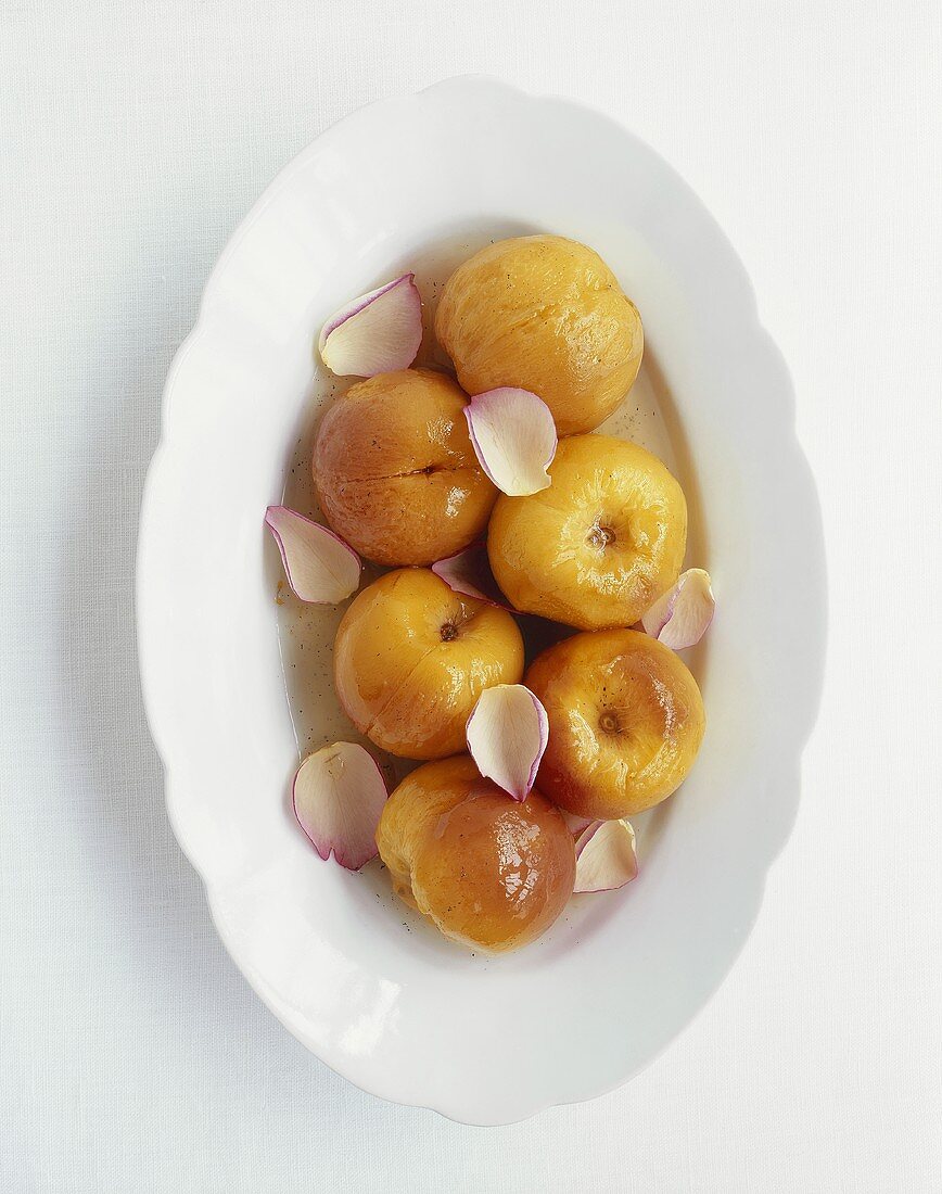 Poached peaches with orange syrup and rose petals
