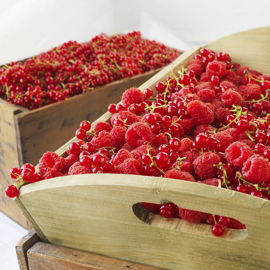 Raspberries and redcurrants in wooden boxes