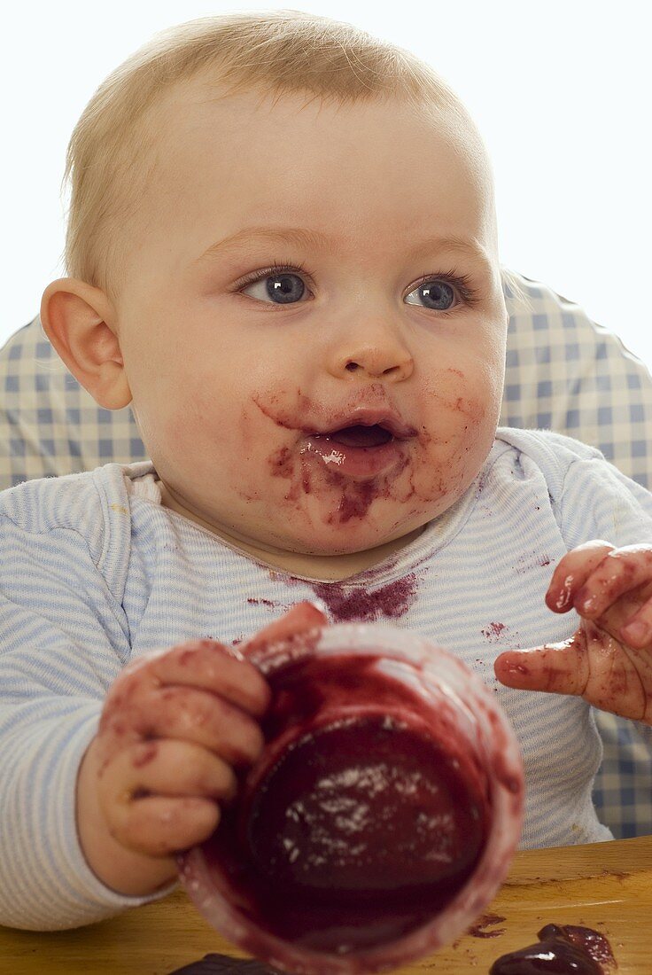 Messy baby with fruit compote