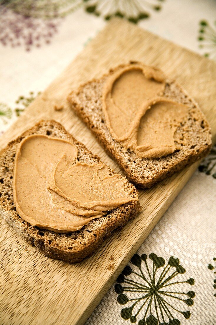 Spreading peanut butter on rye bread