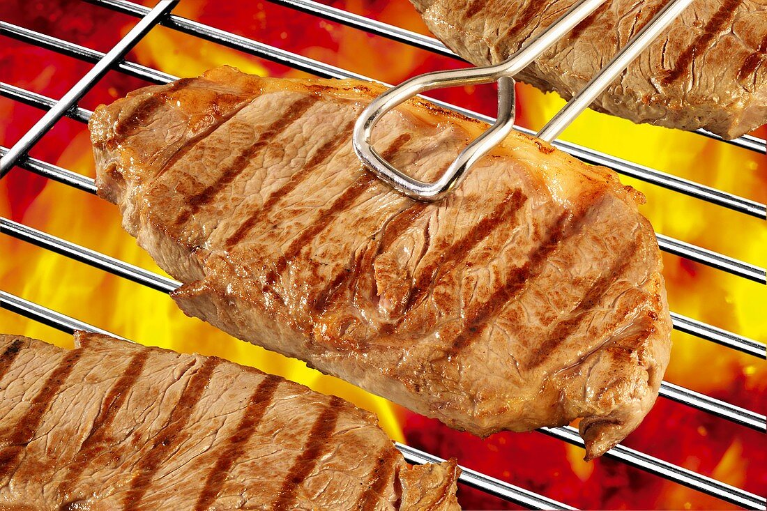 Beef steaks on barbecue