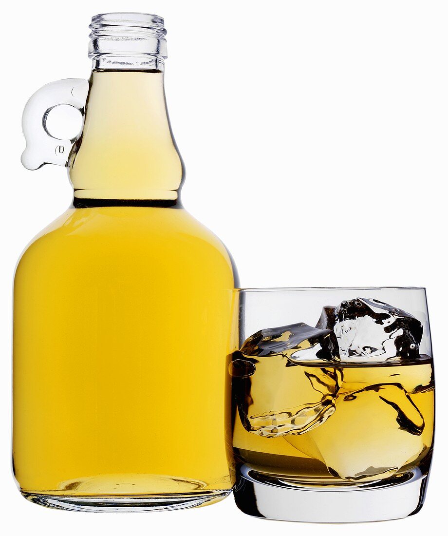 Whiskey in der Flasche und im Glas mit Eiswüfel