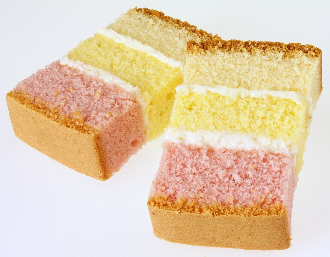 Two slices of three-coloured sponge cake