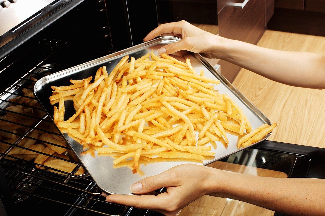 Putting a tray of chips into the oven