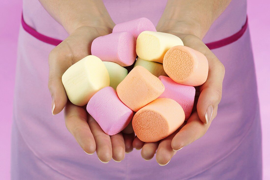 Hands holding coloured marshmallows
