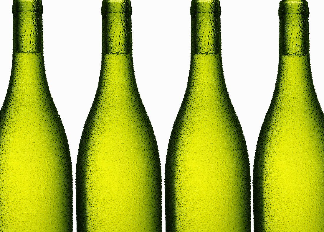 Weißwein in vier grünen Flaschen