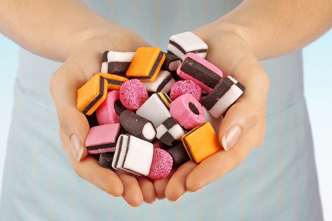 Hands holding coloured liquorice sweets