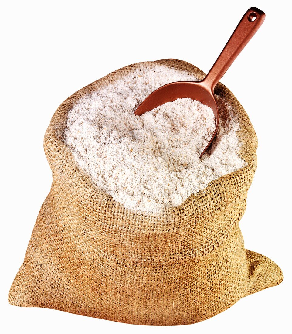 Wholemeal flour in jute sack with scoop