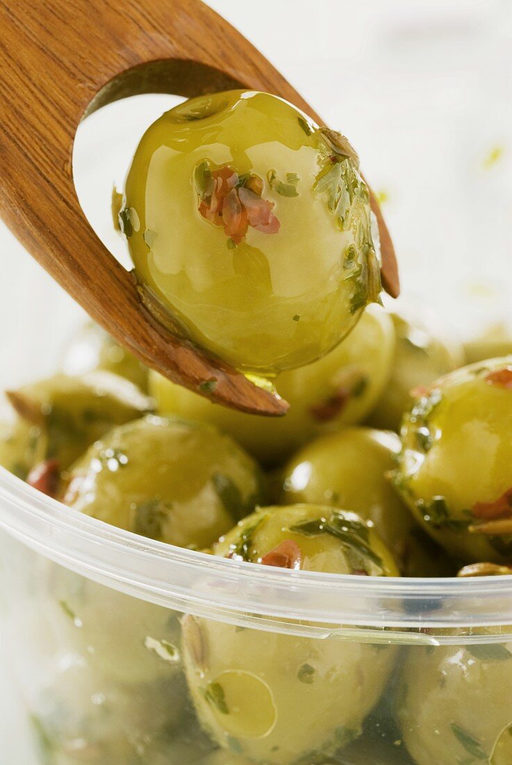 Eingelegte grüne Oliven mit Olivengabel