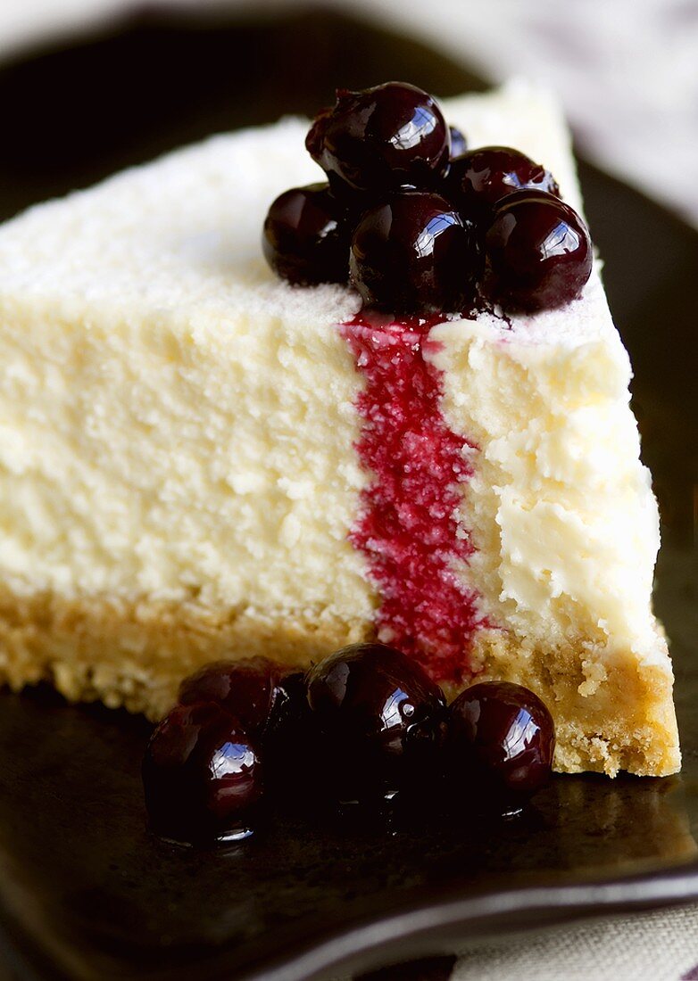 A piece of cheesecake with blackcurrants