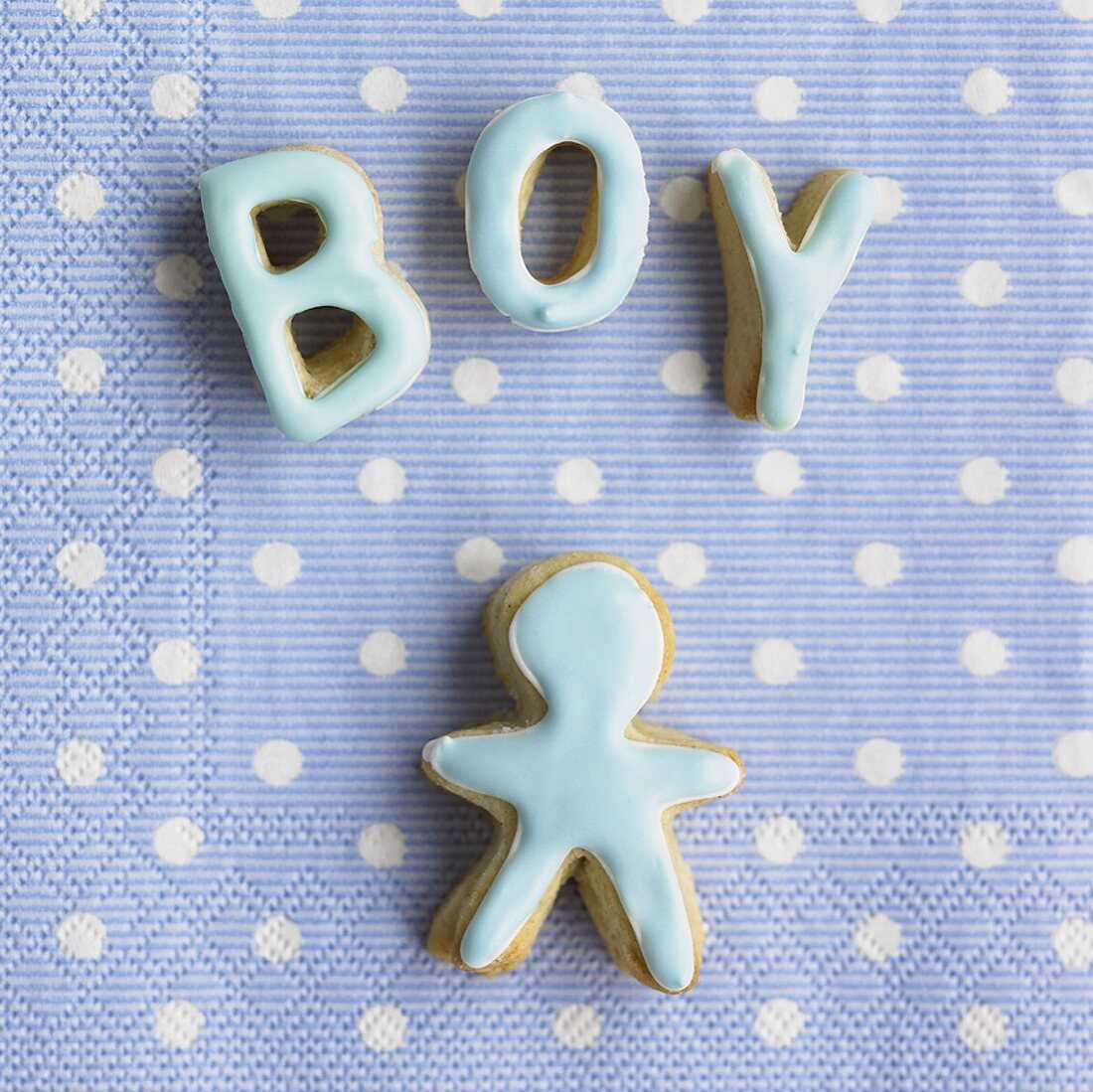 Gebackene Buchstaben 'Boy' und Figur auf einer Serviette