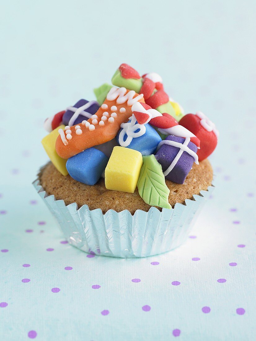 Cupcake decorated with coloured marzipan gifts for Christmas