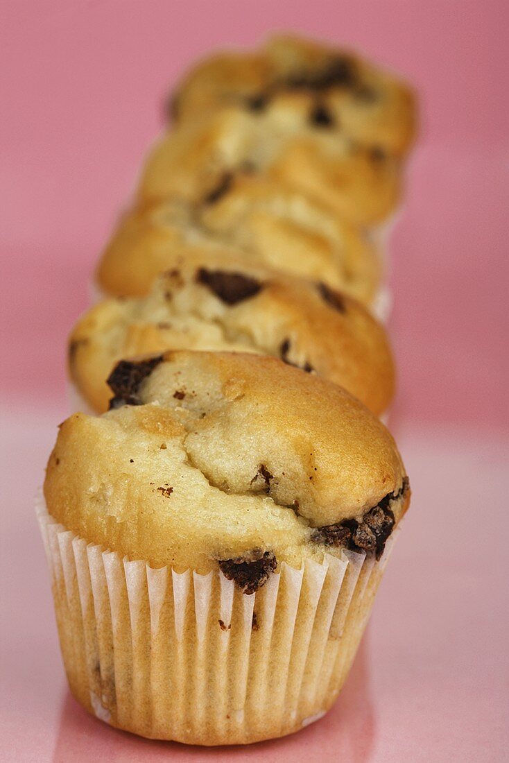 Five chocolate chip muffins in a row