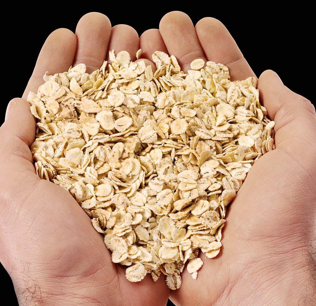 Hands holding rolled oats