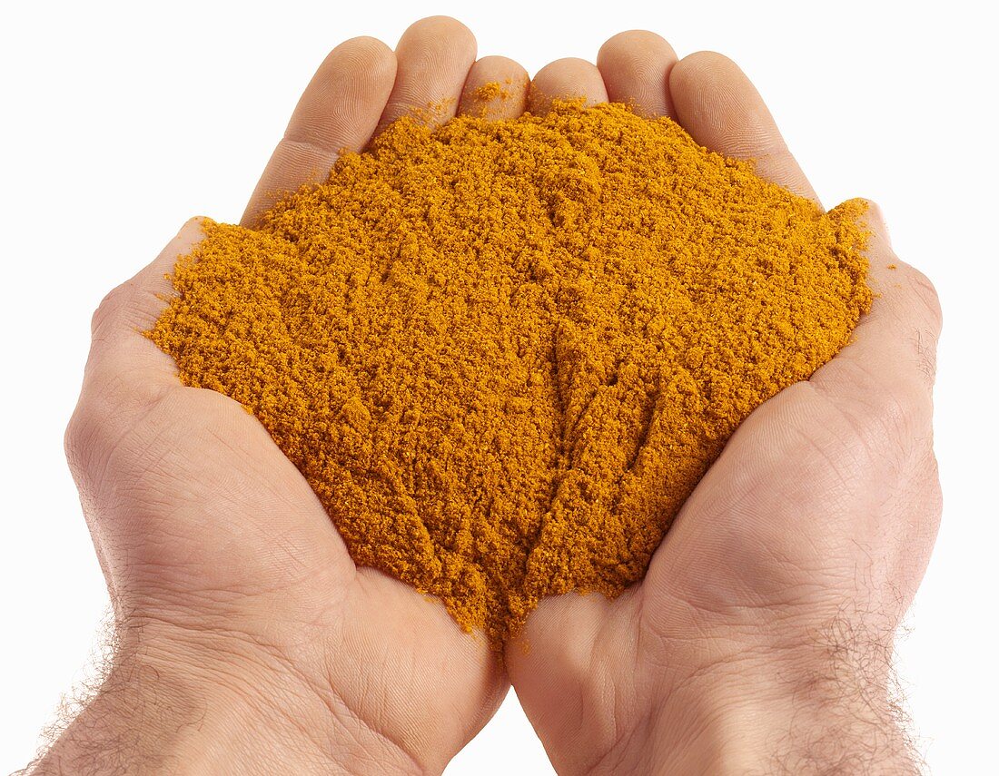 Hands holding curry powder