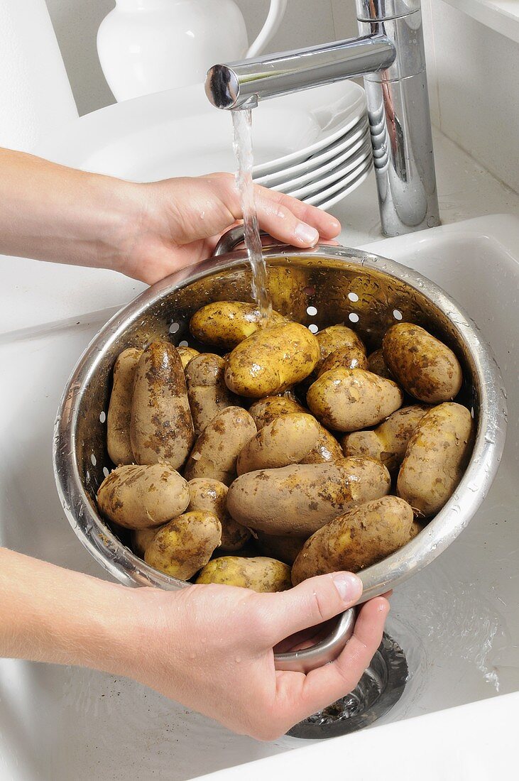 Kartoffeln unter fließendem Wasser waschen