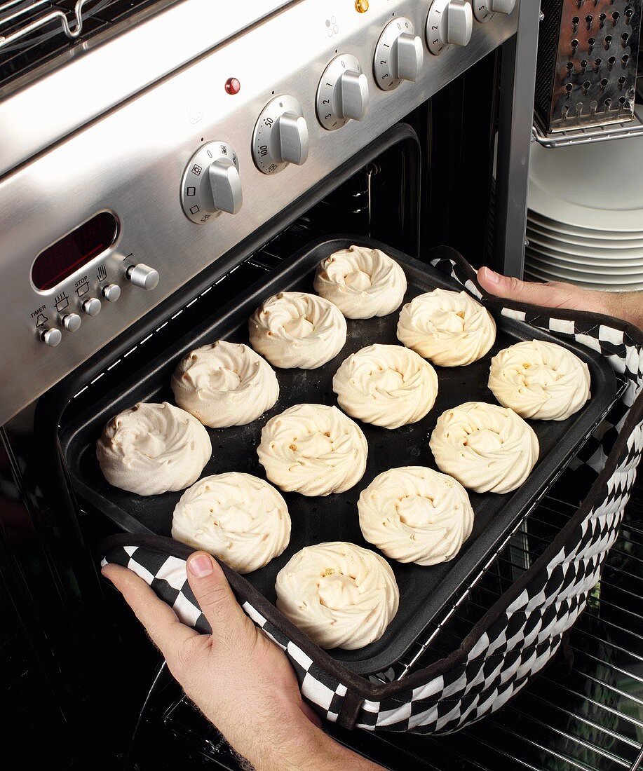 Man taking meringues out of the oven