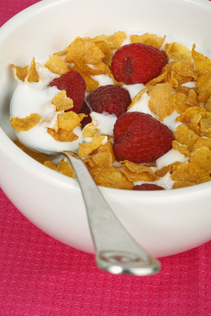 Bowl of cornflakes, yoghurt and raspberries