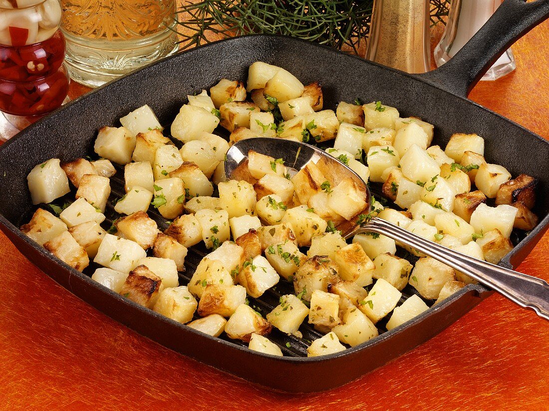 Fried diced potatoes in a grill pan