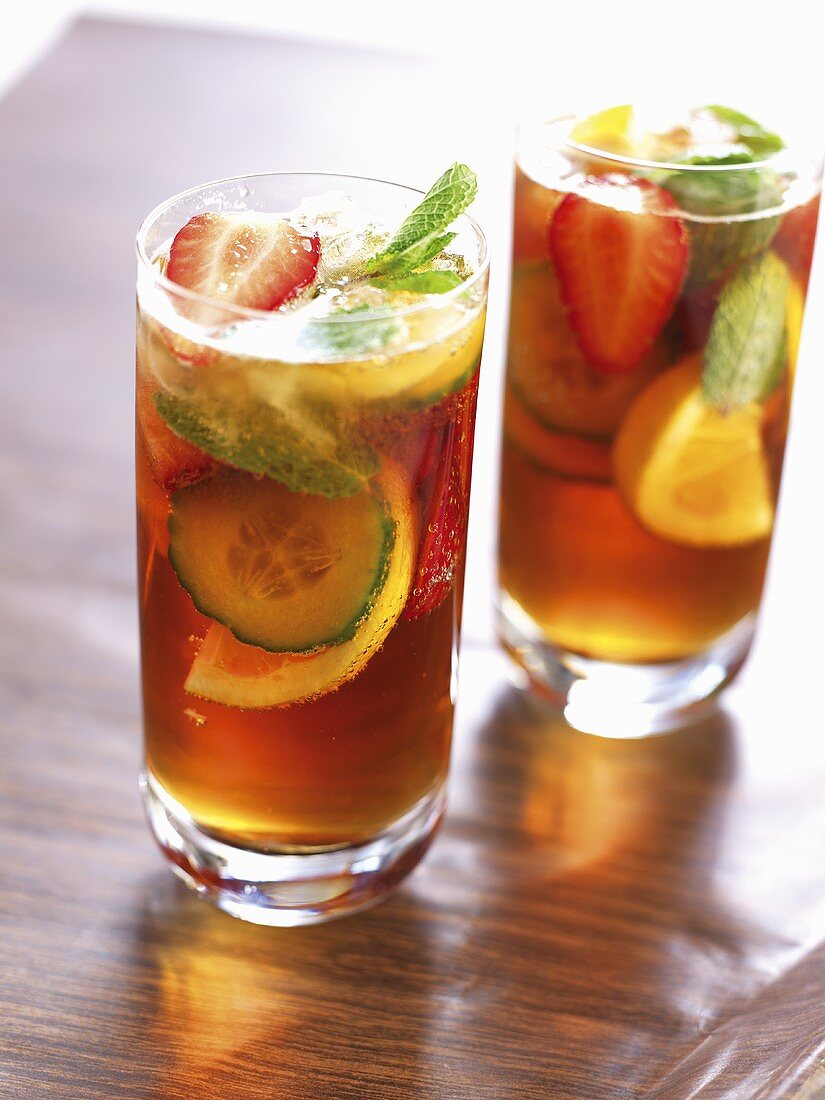 Two glasses of Pimm's cocktail with orange and mint