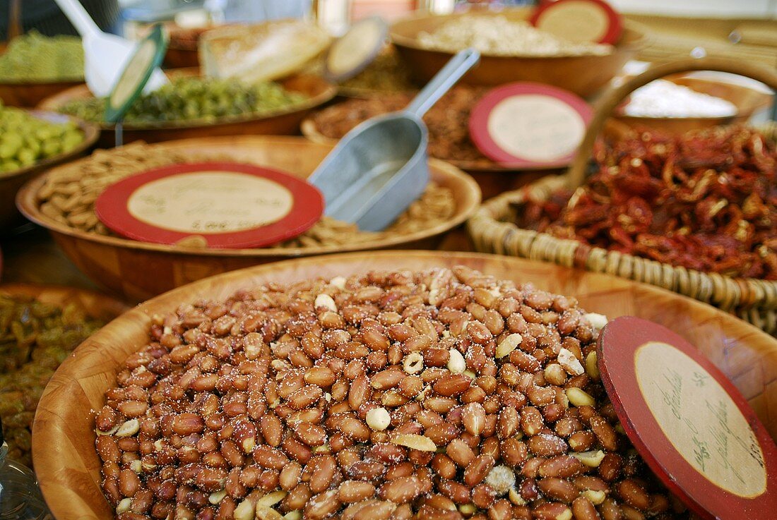Various types of nuts in wooden dishes at a market