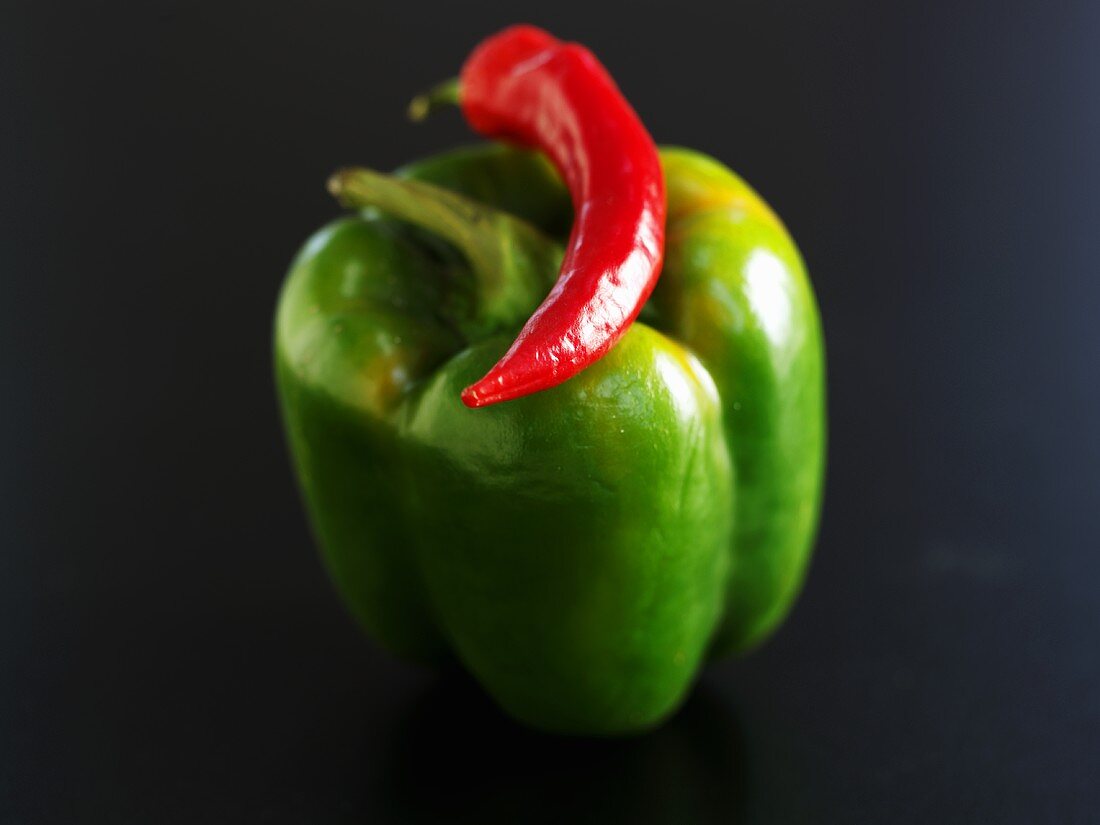 Grüne Paprika mit einer roten Chilischote
