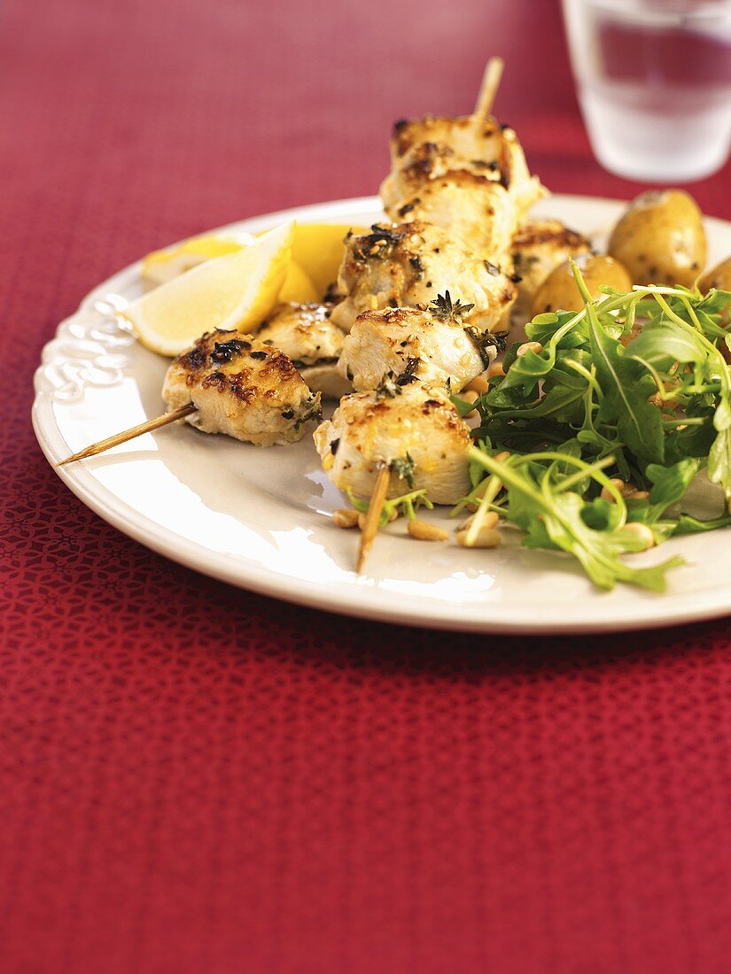 Fried chicken kebabs with potatoes and rocket