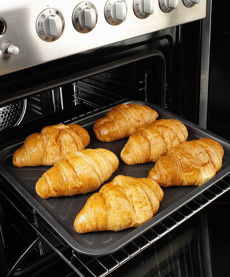 Sechs Gebackene Croisants auf Backblech in einem Ofen