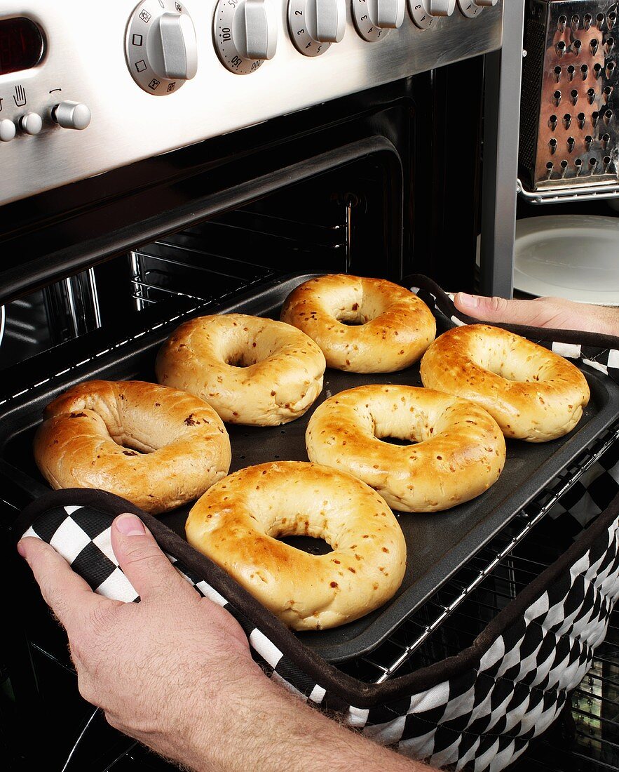 Man taking bagels out of the oven