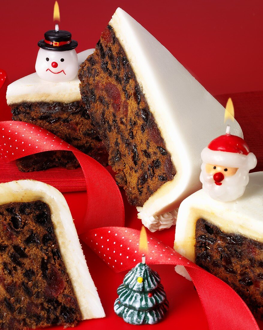 Pieces of Christmas cake with Christmas candles (UK)