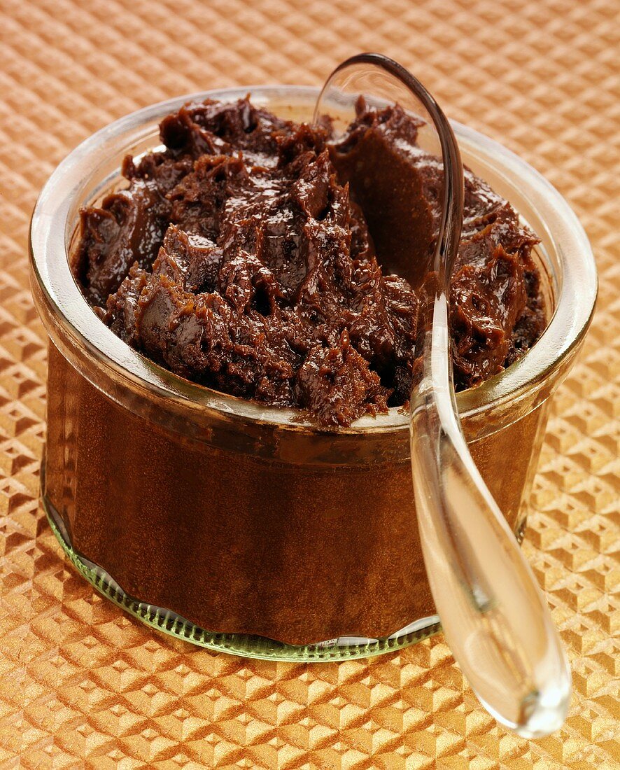 Chocolate mousse in a glass ramekin with plastic spoon