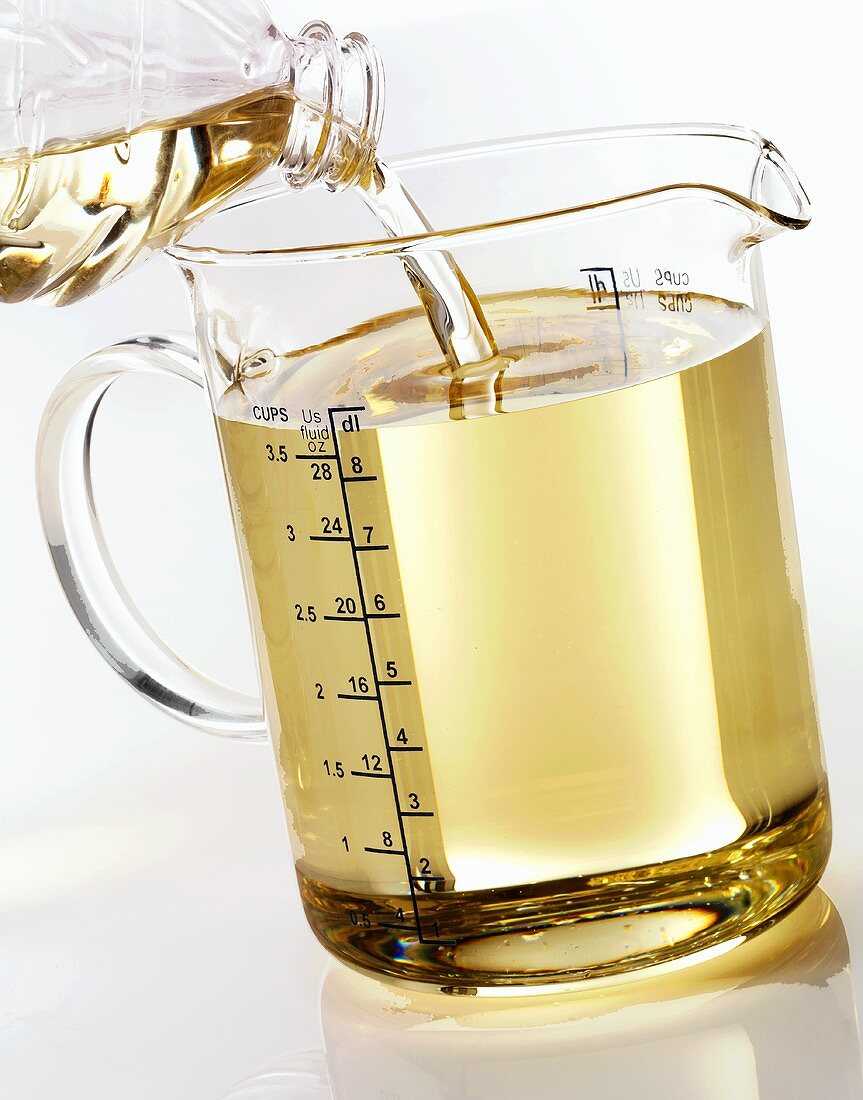 Pouring corn oil into a measuring jug