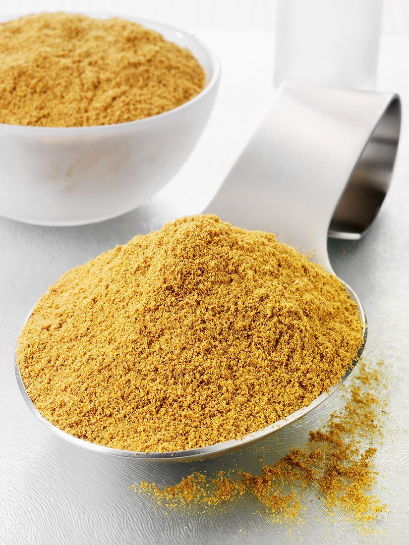Ground cumin on a spoon and in a glass bowl