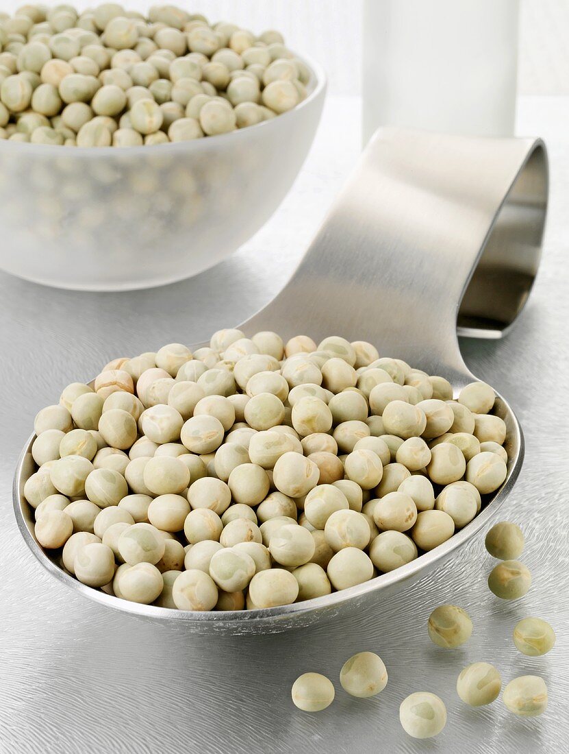 Dried peas on a spoon and in a glass bowl