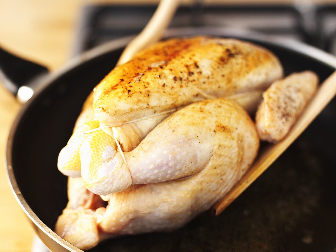 Browning a whole chicken in a frying pan