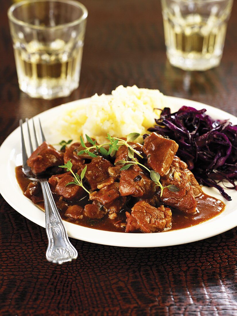 Wild boar and beer stew with mashed potato and red cabbage