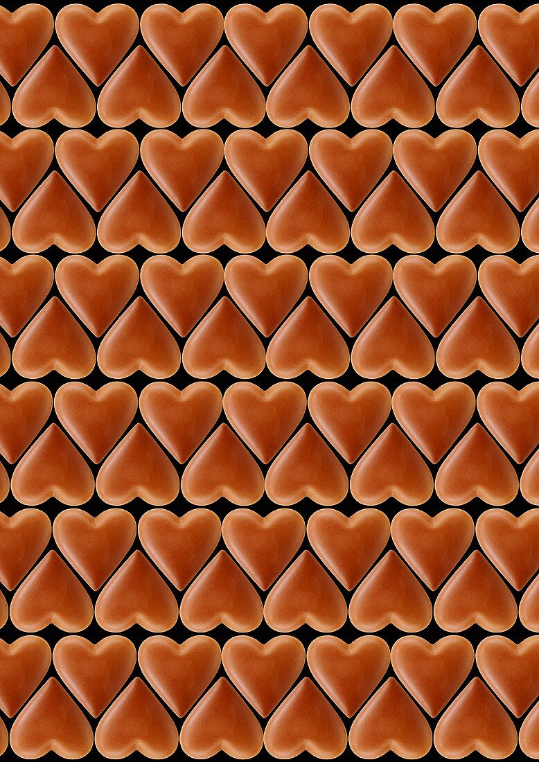 Chocolate hearts arranged in rows, black background