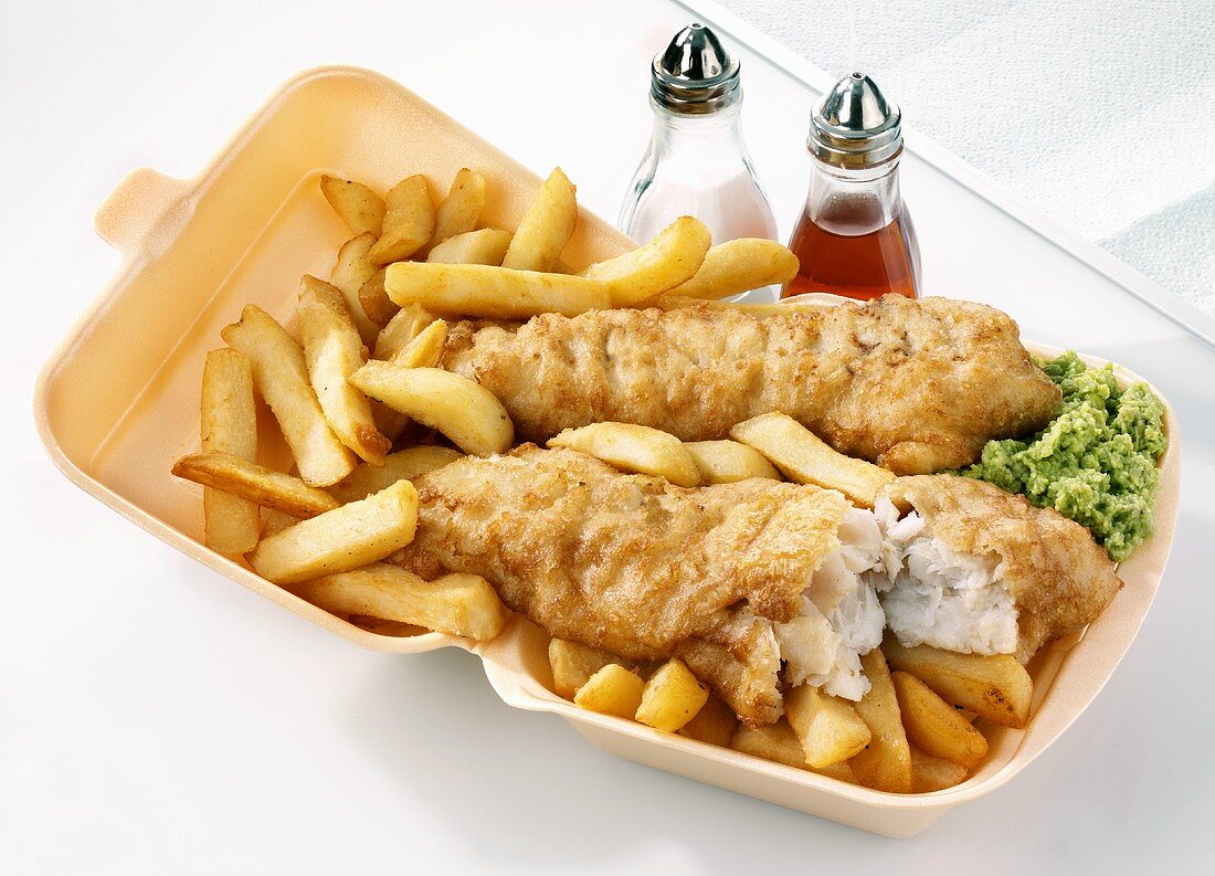 Fish and chips with mushy peas in a polystyrene container