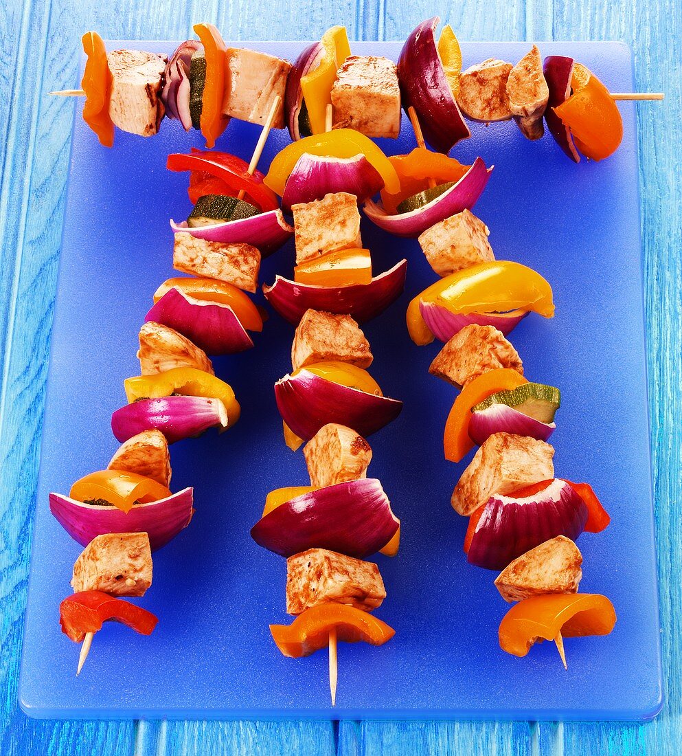 Four grilled chicken and vegetable kebabs