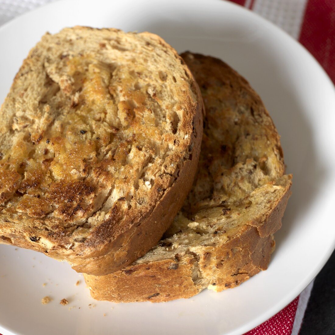 Getoastete Brötchen-Hälften mit Butter auf einem Teller