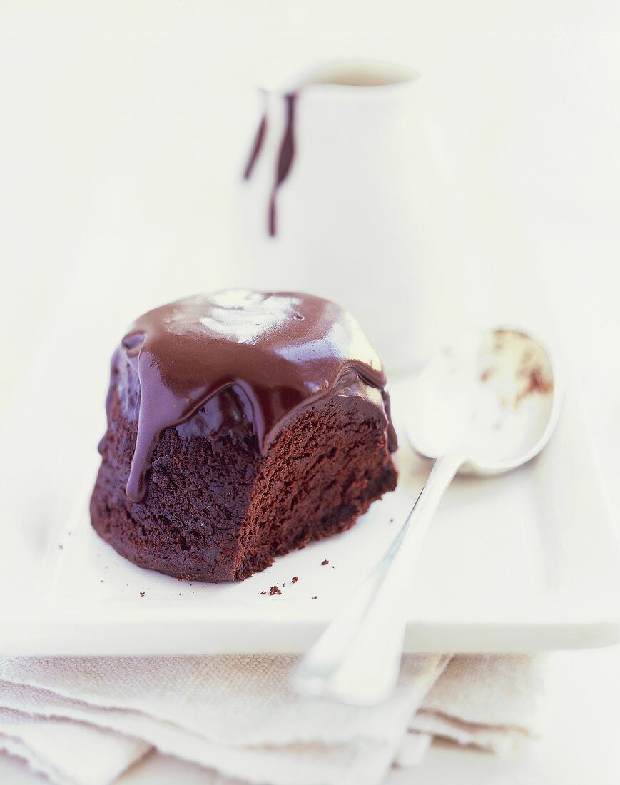 Individual chocolate pudding with chocolate sauce & a spoon