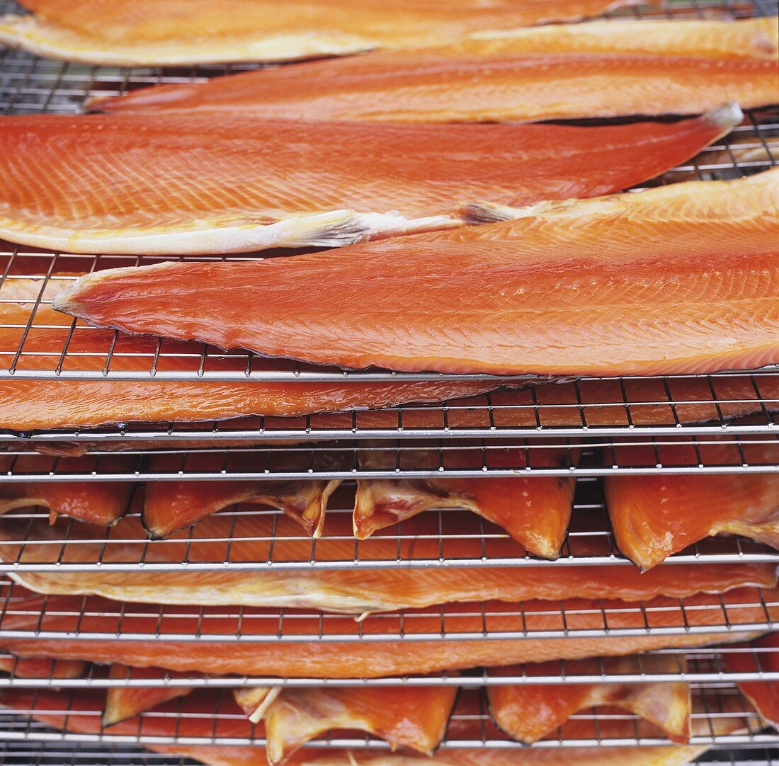 Sides of salmon on racks in a smoking oven