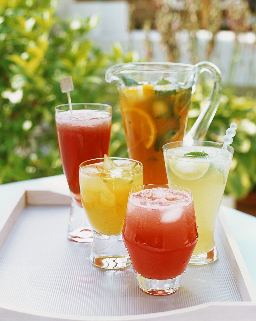 Iced tea and fruit cocktails on a tray out of doors