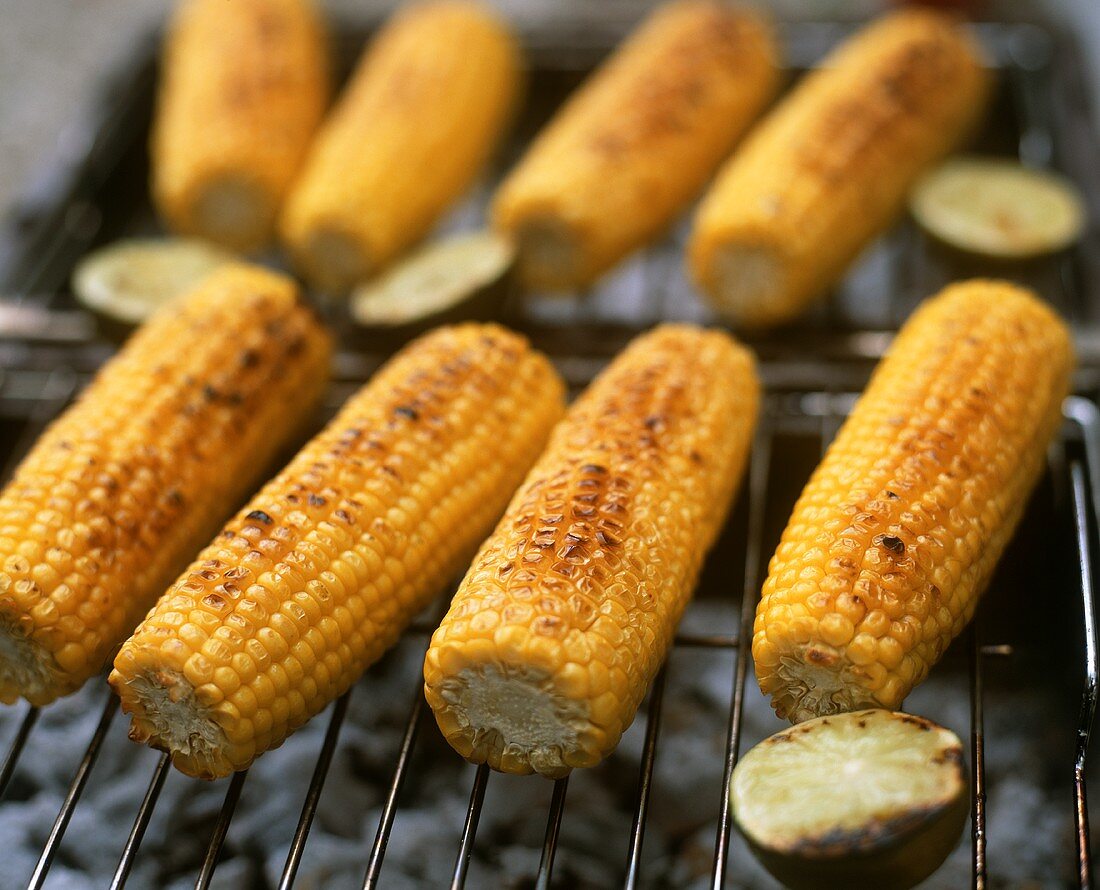 Corn on the cob and lime halves on barbecue
