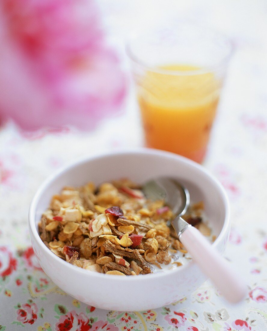 Müsli mit Milch und einem Glas Orangensaft